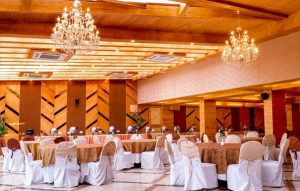 Indoor banquet hall at Hotel Willow Banks Shimla elegantly decorated for a wedding reception, with stage, dance floor, and ambient lighting.