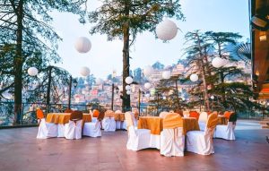 Guests seated at a beautifully decorated outdoor terrace banquet overlooking Shimla hills at Hotel Willow Banks.